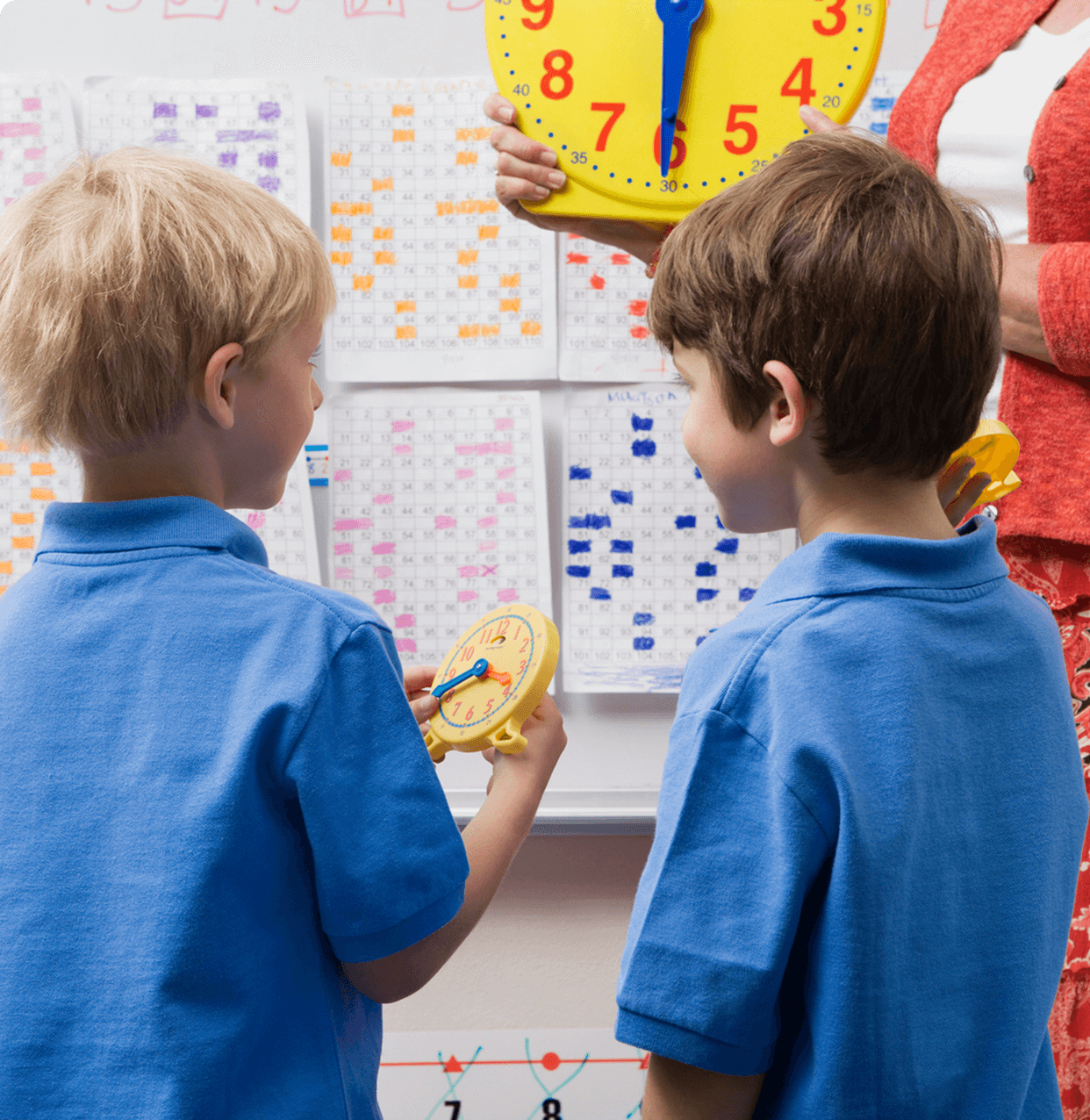 Children learning to tell time with clocks.