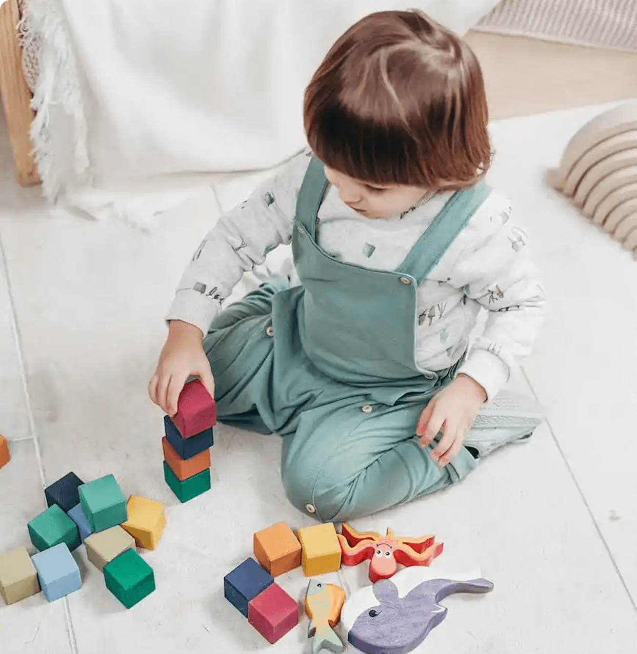 Child playing with colorful stacking blocks.